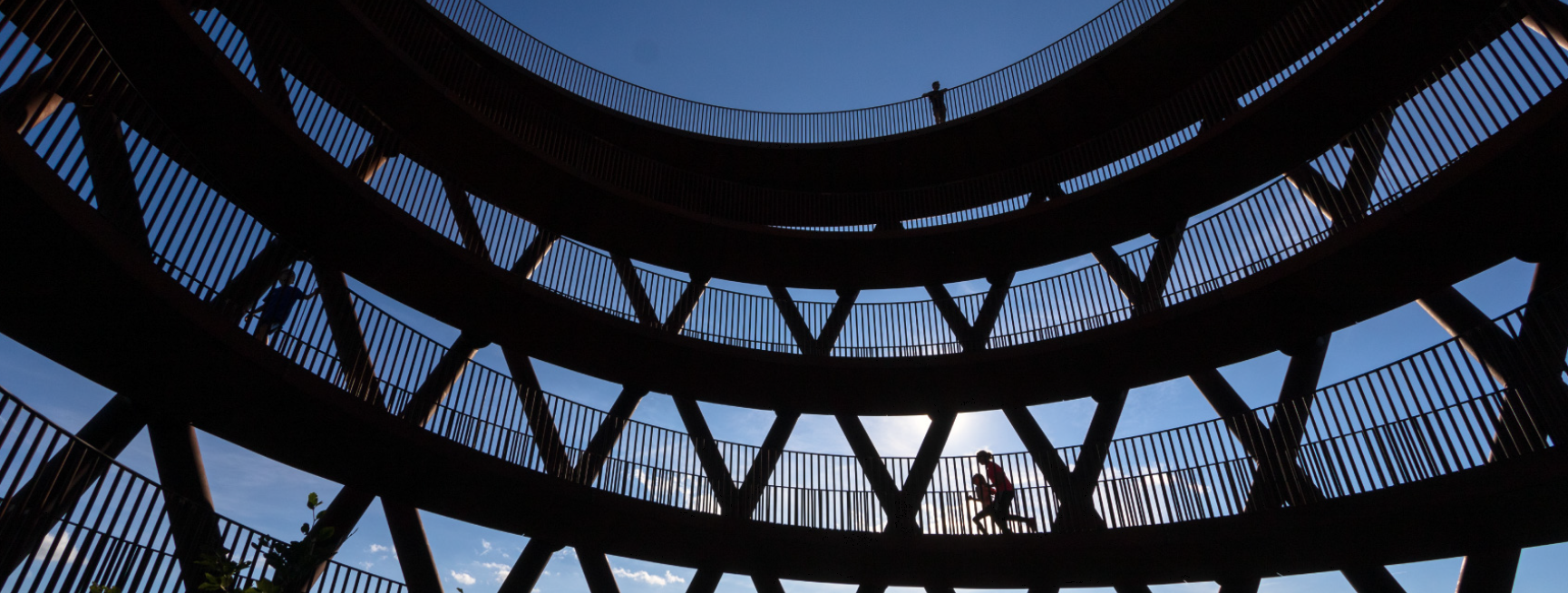A photo shows a low-angle view of silhouettes of people walking or running in the high observation tower, Camp Adventures in Haslev on the South Island of New Zealand.