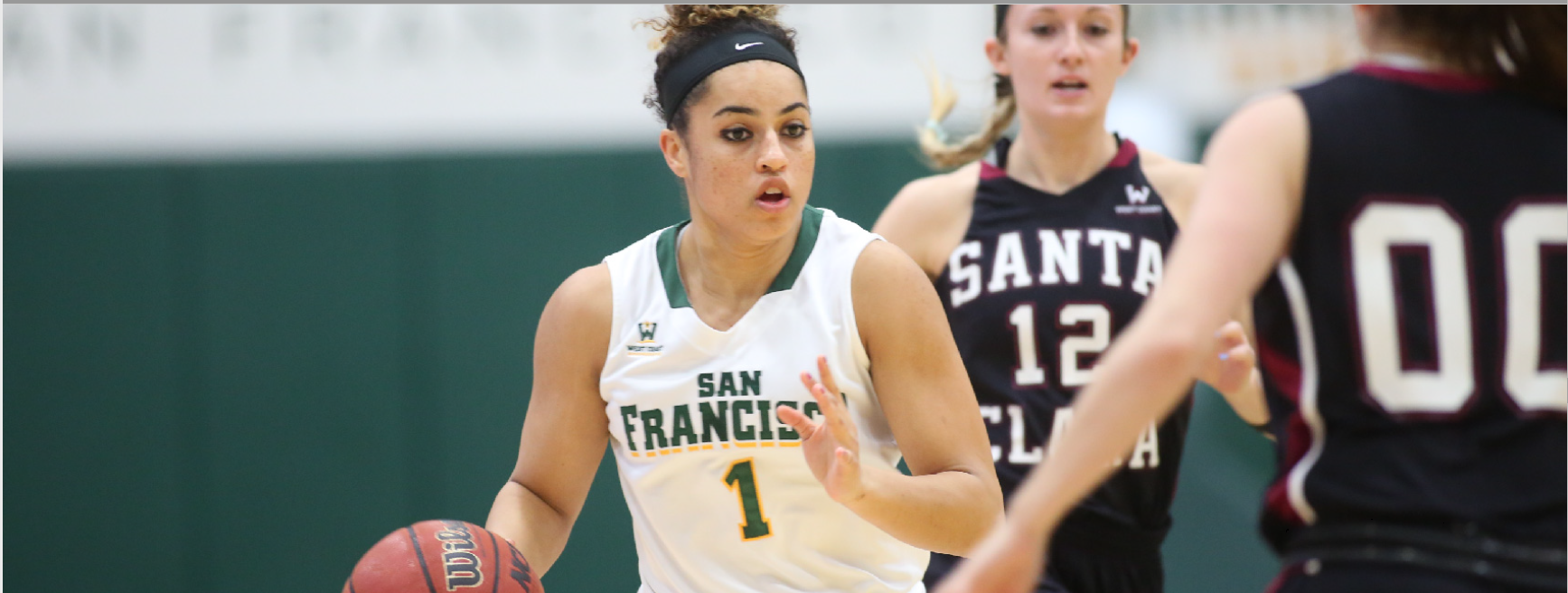 A photo shows three female basketball players playing basketball.