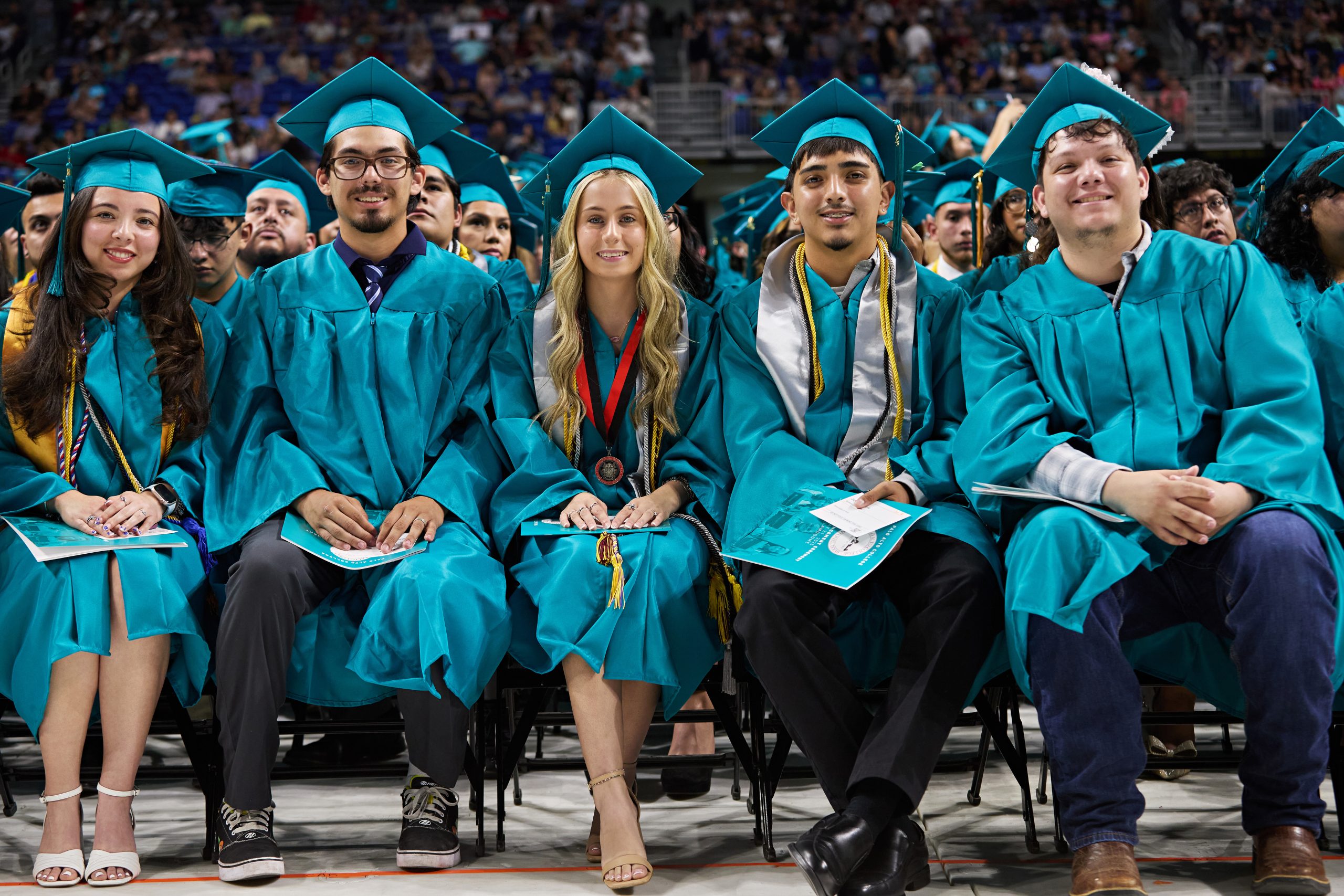 Five Palo Alto College students in regalia at graduation.