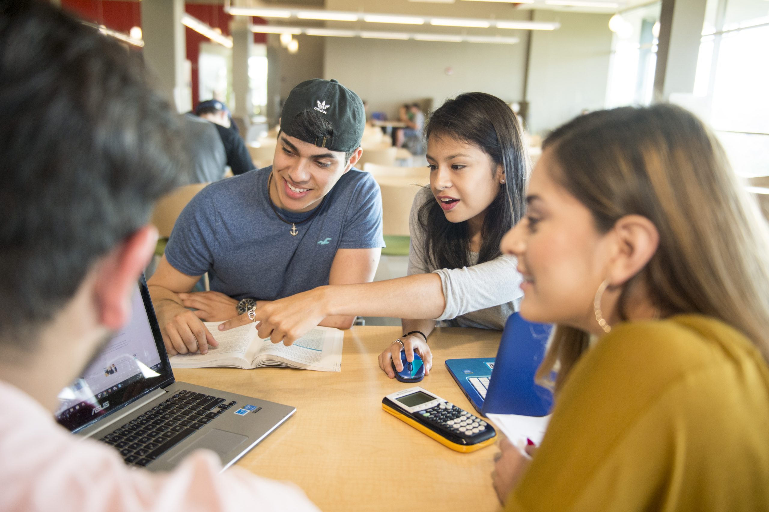 Group of four students at a table studying together.