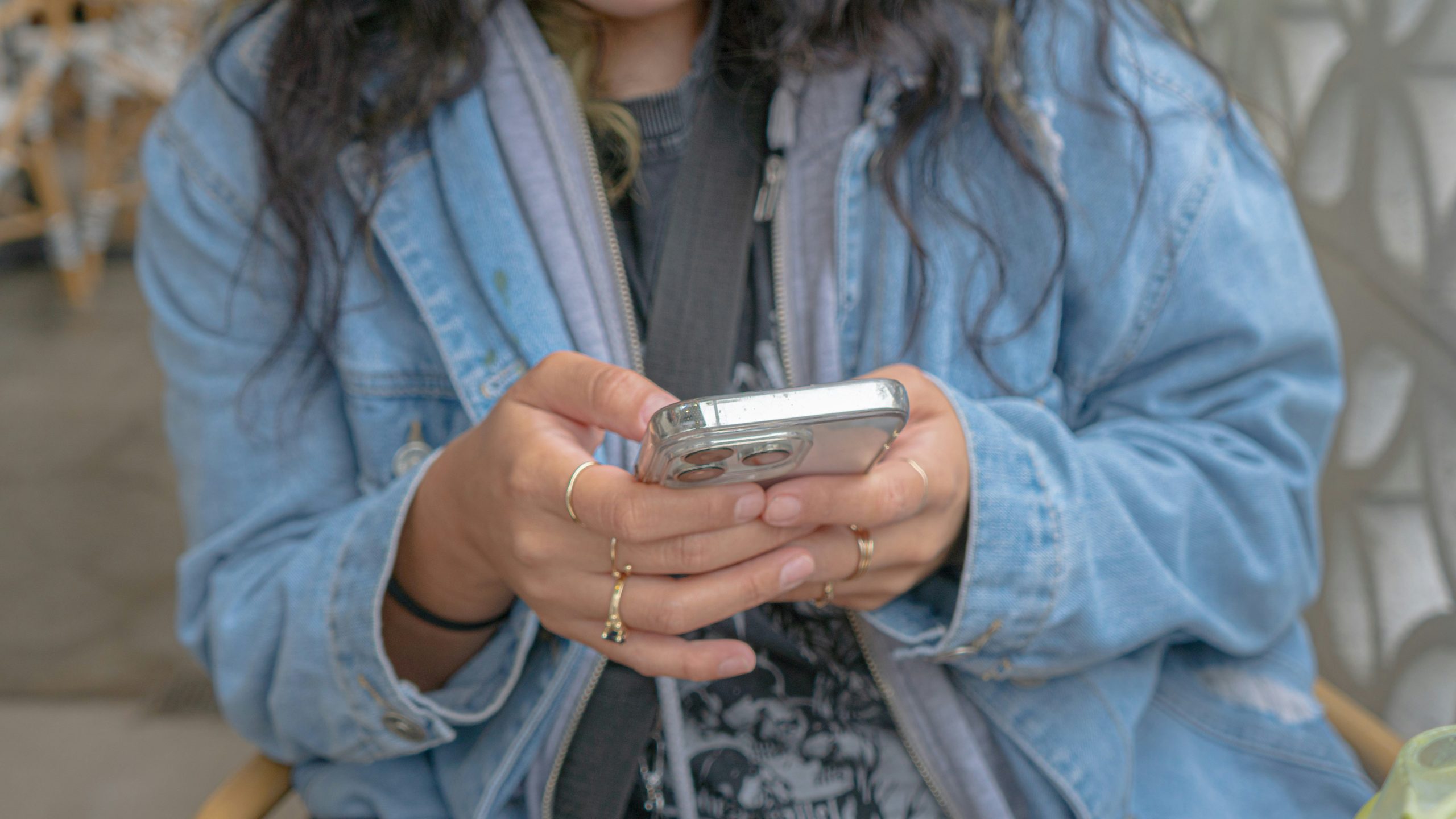 A close-up of a cell phone in a woman’s hands.